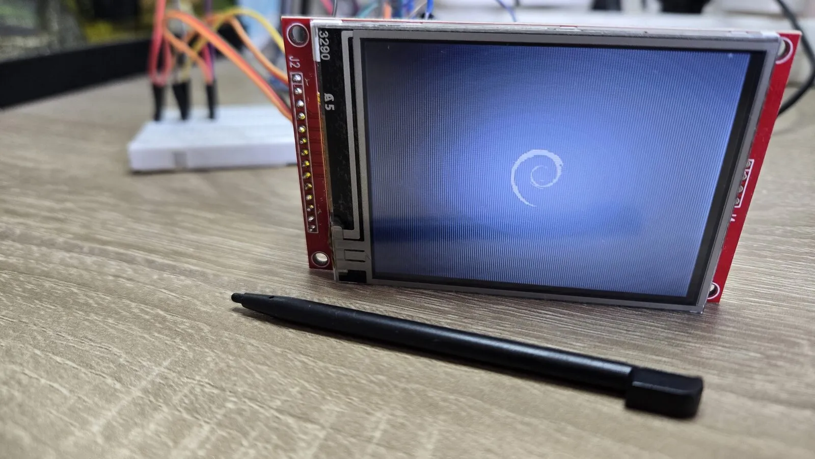 The Debian logo, a white swirl on a blue background, on the LCD